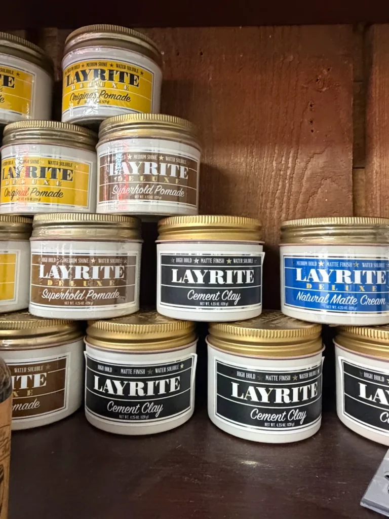 Stacked tins of Layrite pomade, cement clay and matte cream in Old Town San Diego